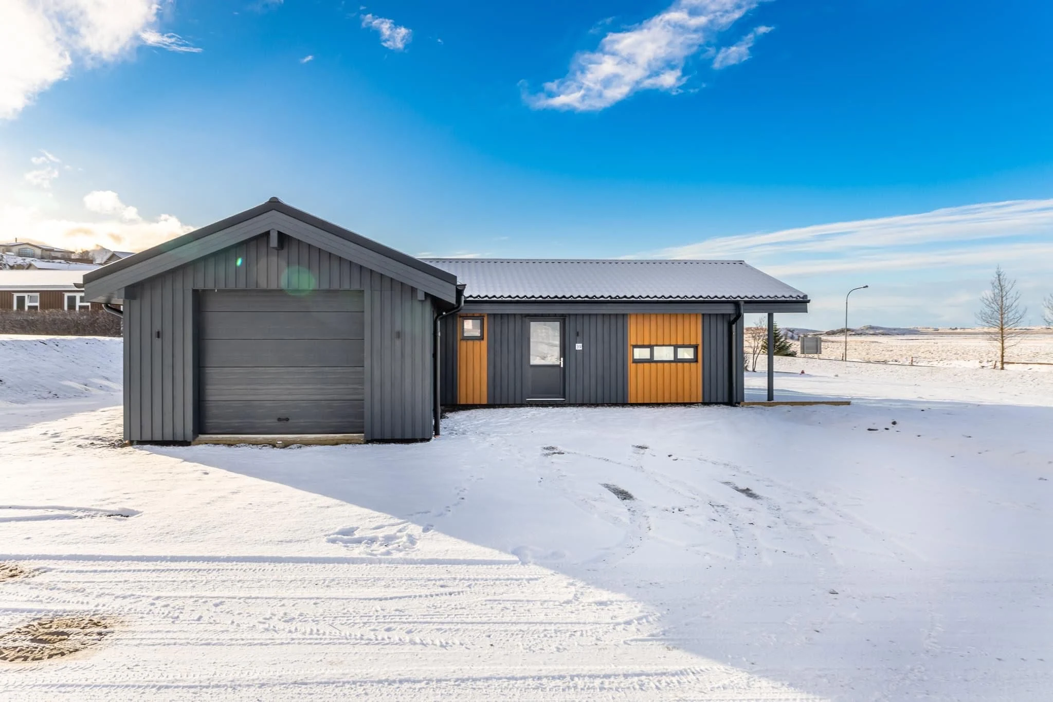 Front façade of one of the Iceland homes with garage and puffin-inspired cladding