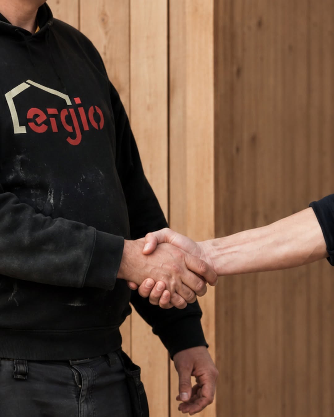 Apretón de manos frente a un revestimiento de madera que representa la coordinación entre fábrica y obra