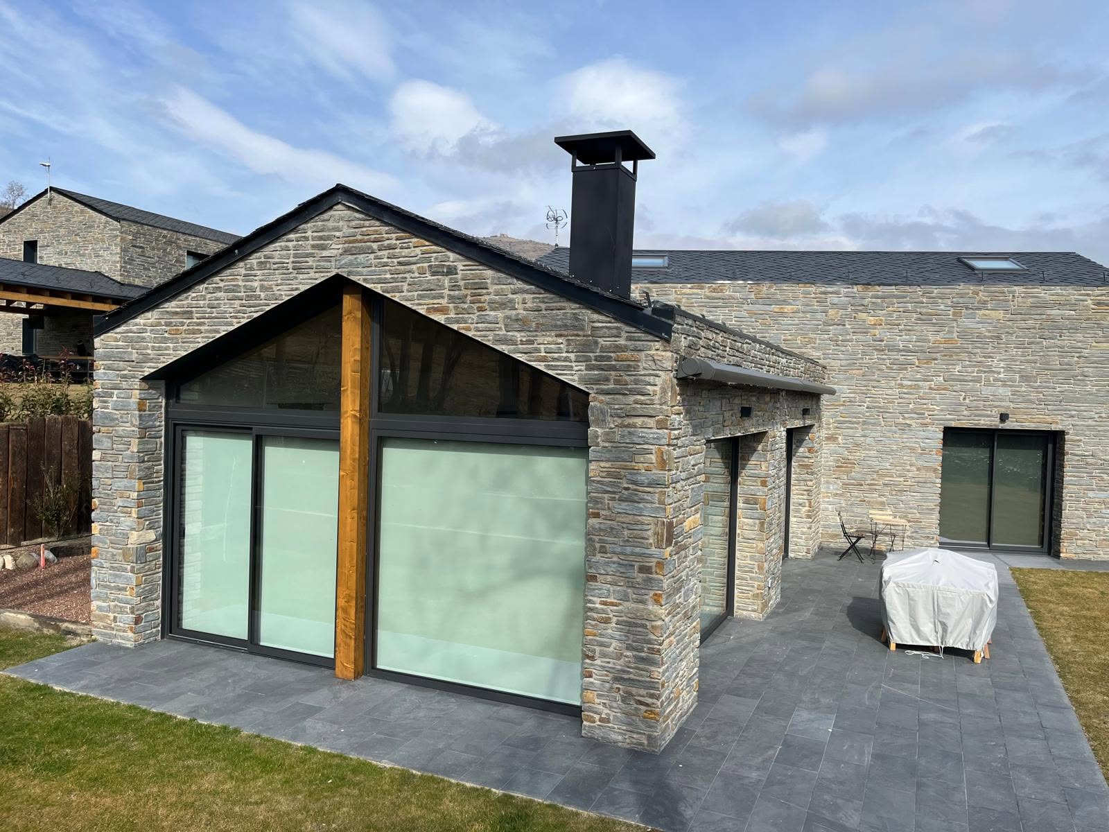 Terrace and glazed gable of the mixed-material residence